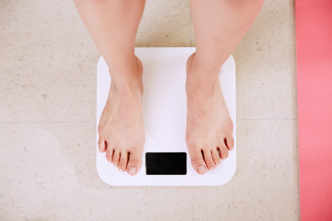 A person's bare feet standing on white bathroom scales