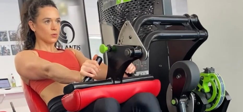 A woman using a leg press machine in a gym